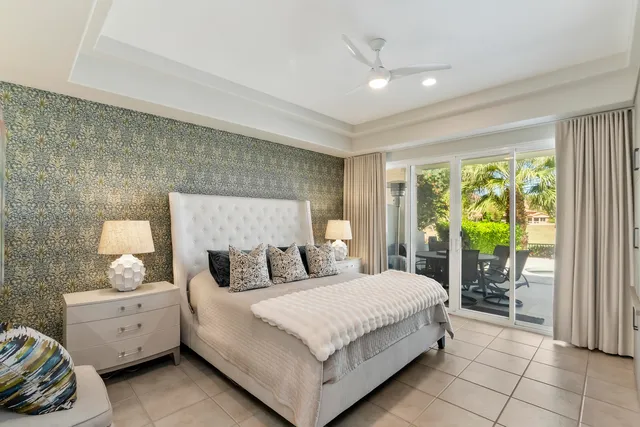 a bedroom with a bed and large windows