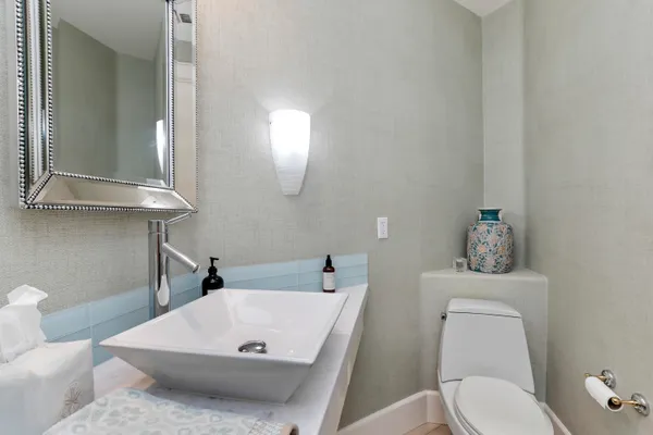 a bathroom with a sink a toilet and mirror