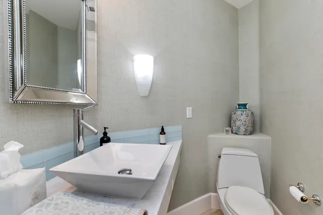 a bathroom with a sink a toilet and mirror