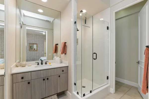 a bathroom with a shower sink and mirror