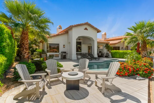 a view of a patio with couches table and chairs and potted plants