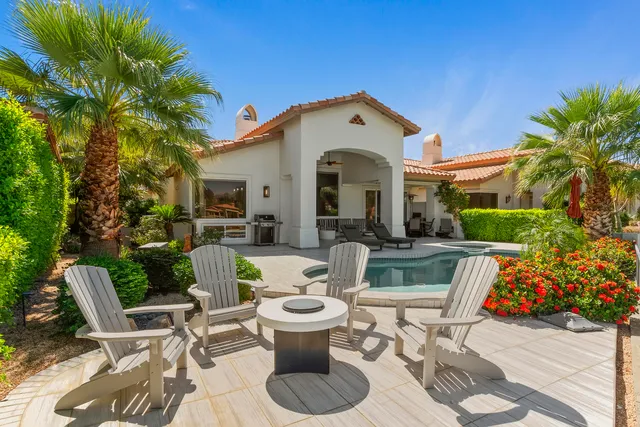 a view of a patio with couches table and chairs and potted plants