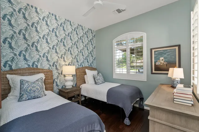 a bedroom with two beds and wooden floor