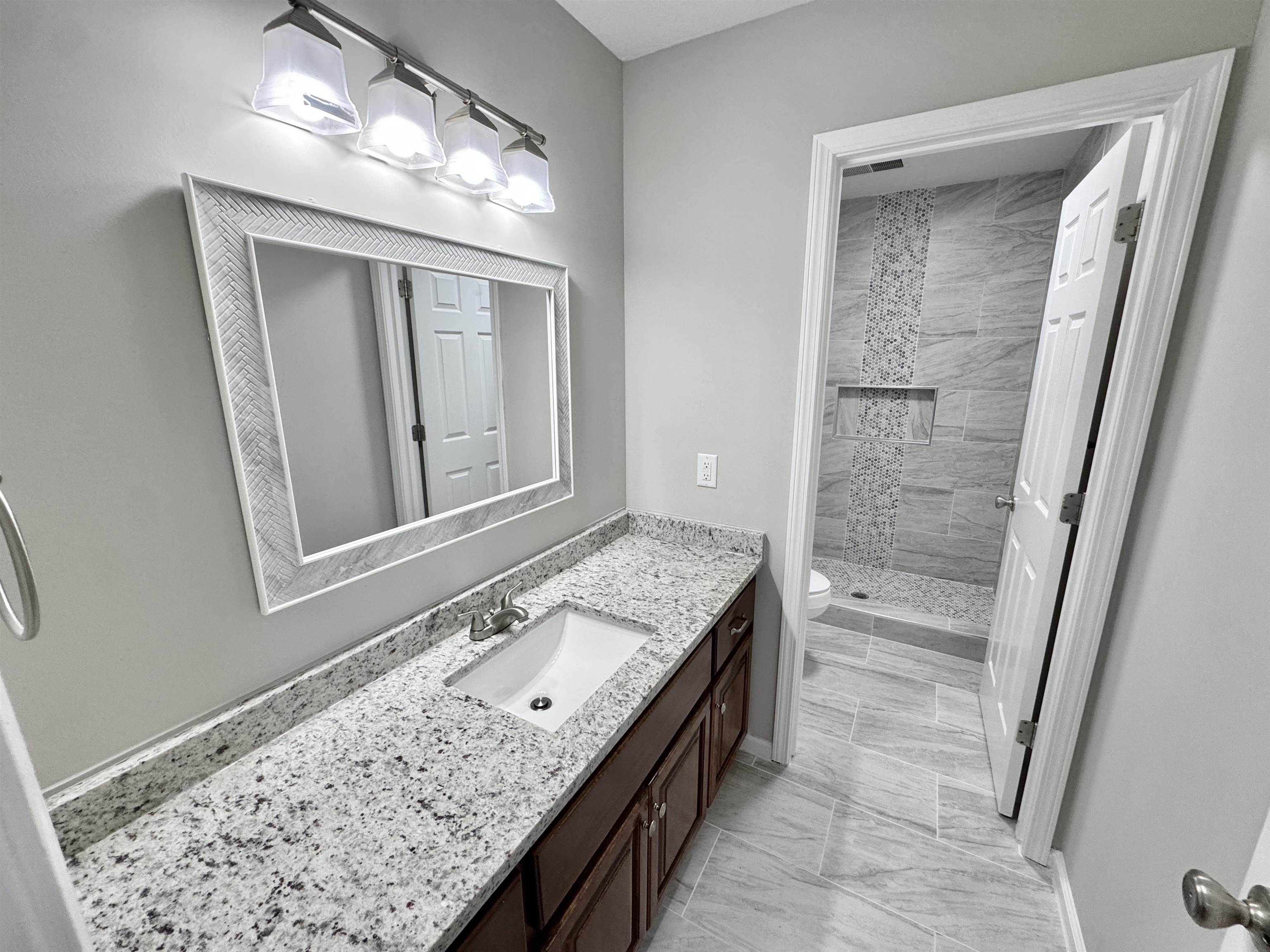 526 Stone Ridge Pinson, TN 38366 - Photo 18 of 39 Full bathroom with vanity, a stall shower, and light marble finish flooring