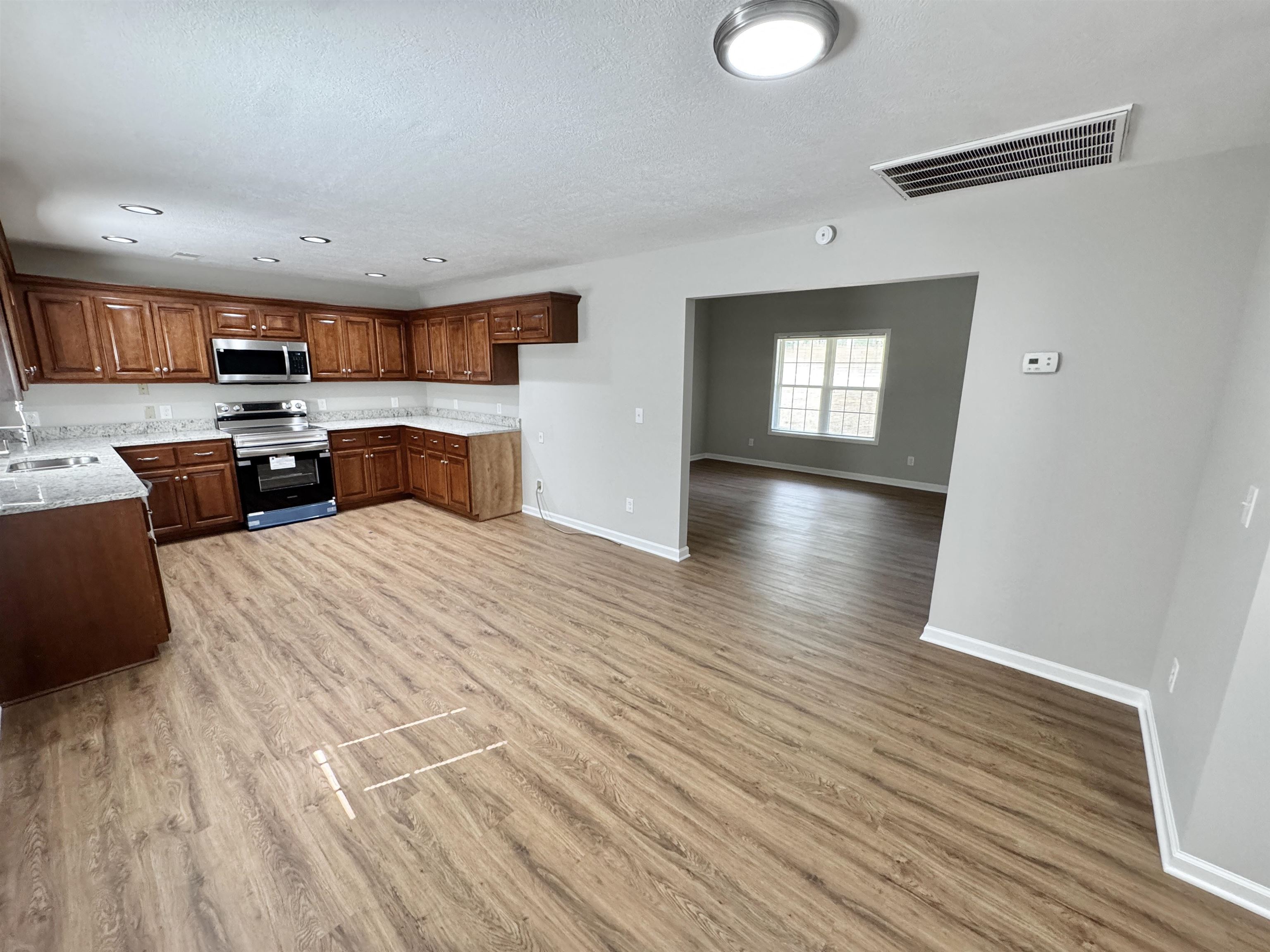 526 Stone Ridge Pinson, TN 38366 - Photo 8 of 39 Kitchen with stainless steel appliances, light wood finished floors, recessed lighting, light stone countertops, and brown cabinetry