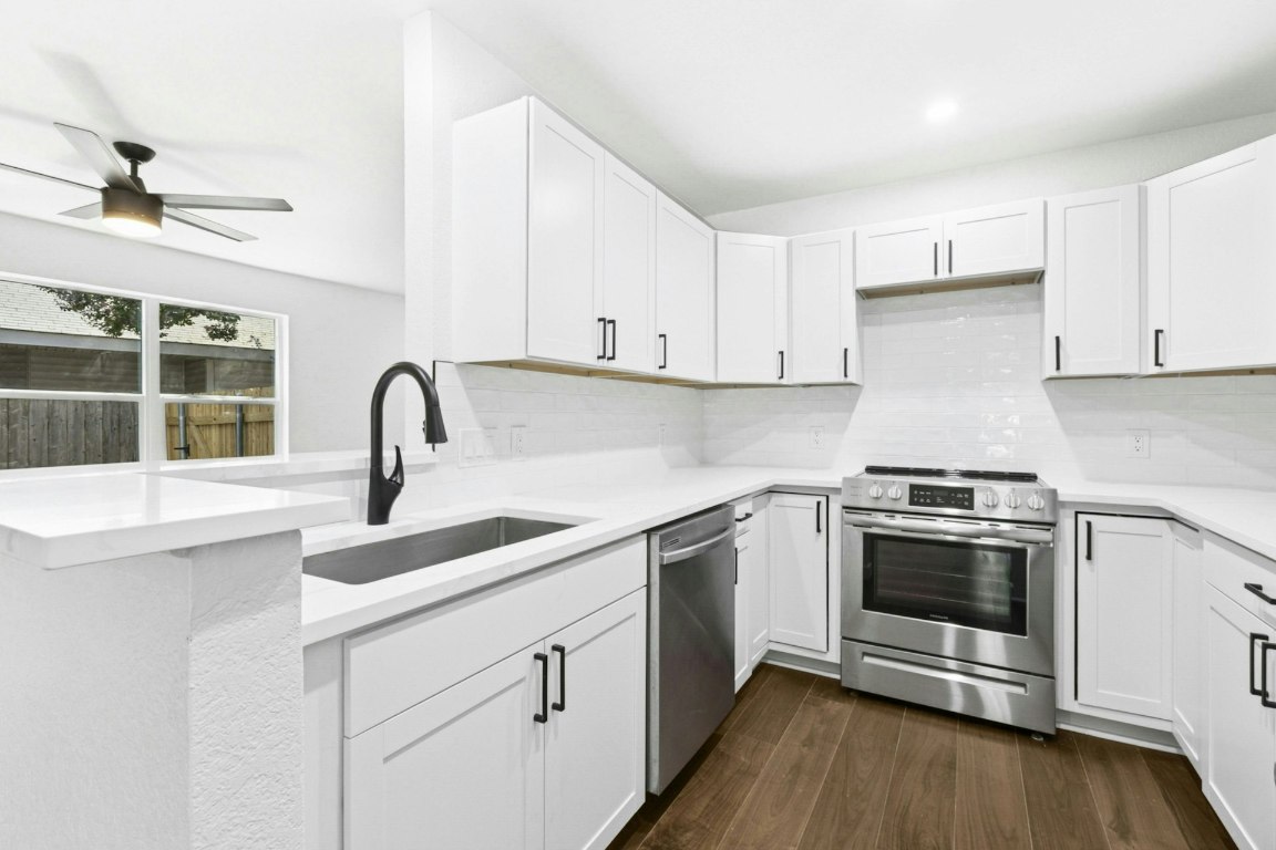 2129 Redwing Way Round Rock, TX 78664 - Photo 11 of 27 a kitchen with stainless steel appliances granite countertop a stove and white cabinets