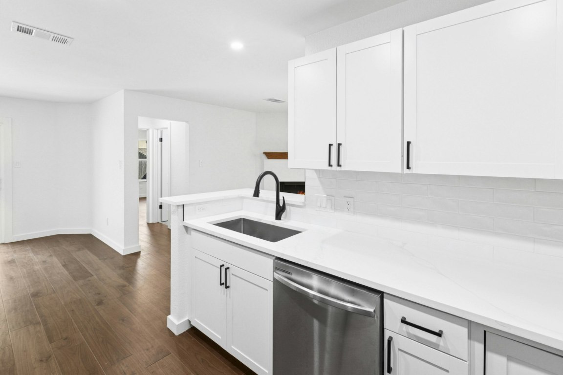 2129 Redwing Way Round Rock, TX 78664 - Photo 12 of 27 a kitchen with a sink cabinets and wooden floor