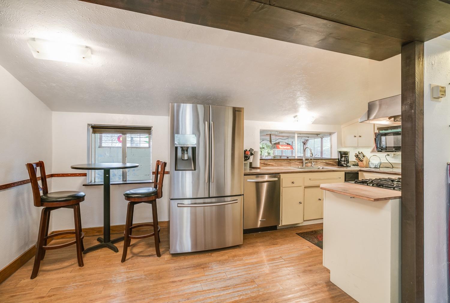 267 Burnham Road Oak View, CA 93022 - Photo 6 of 20 a kitchen with a refrigerator a microwave oven dining table and chairs