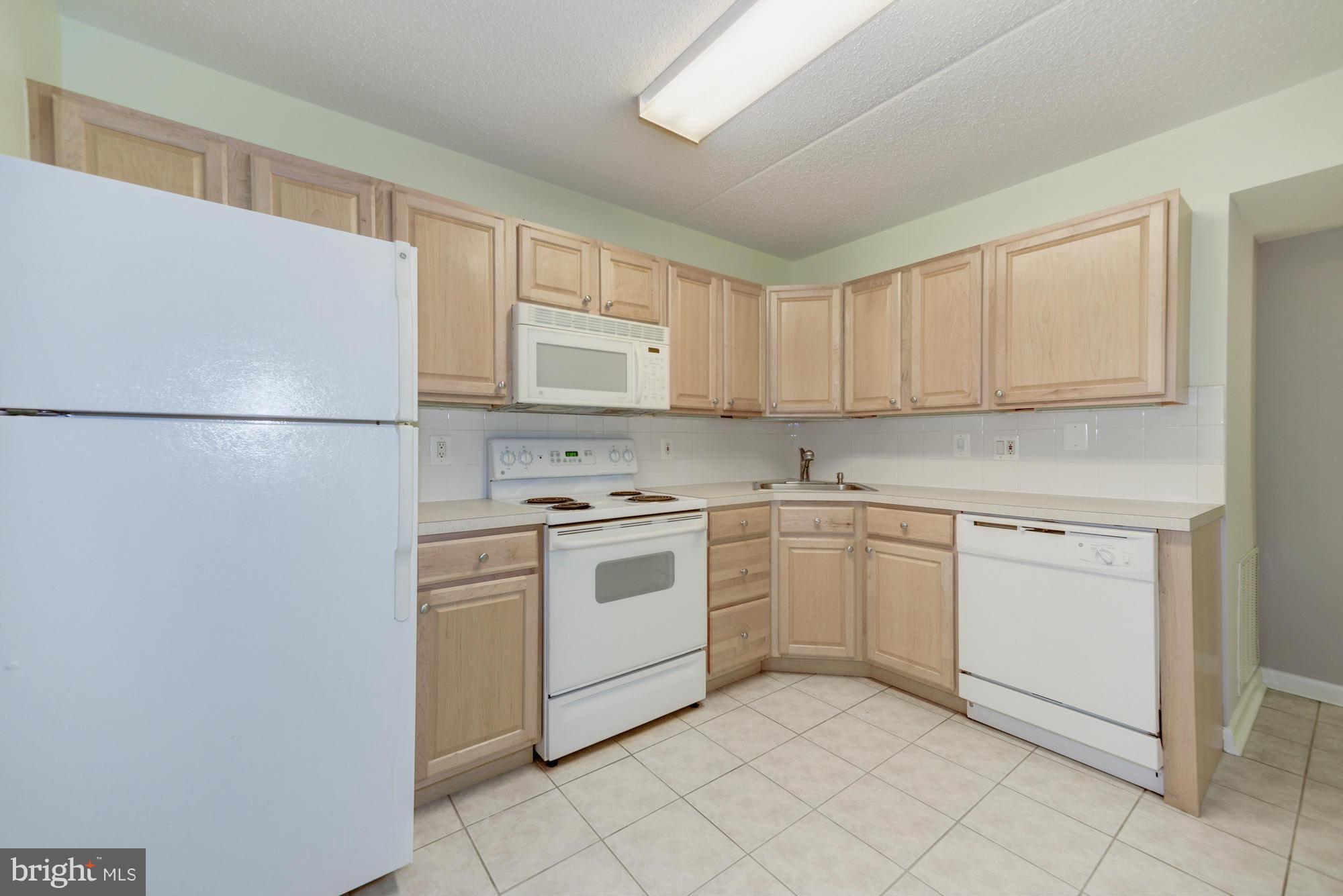 11727 Ledura Court, Unit T2 Reston, VA 20191 - Photo 8 of 18 a kitchen with white cabinets and white appliances