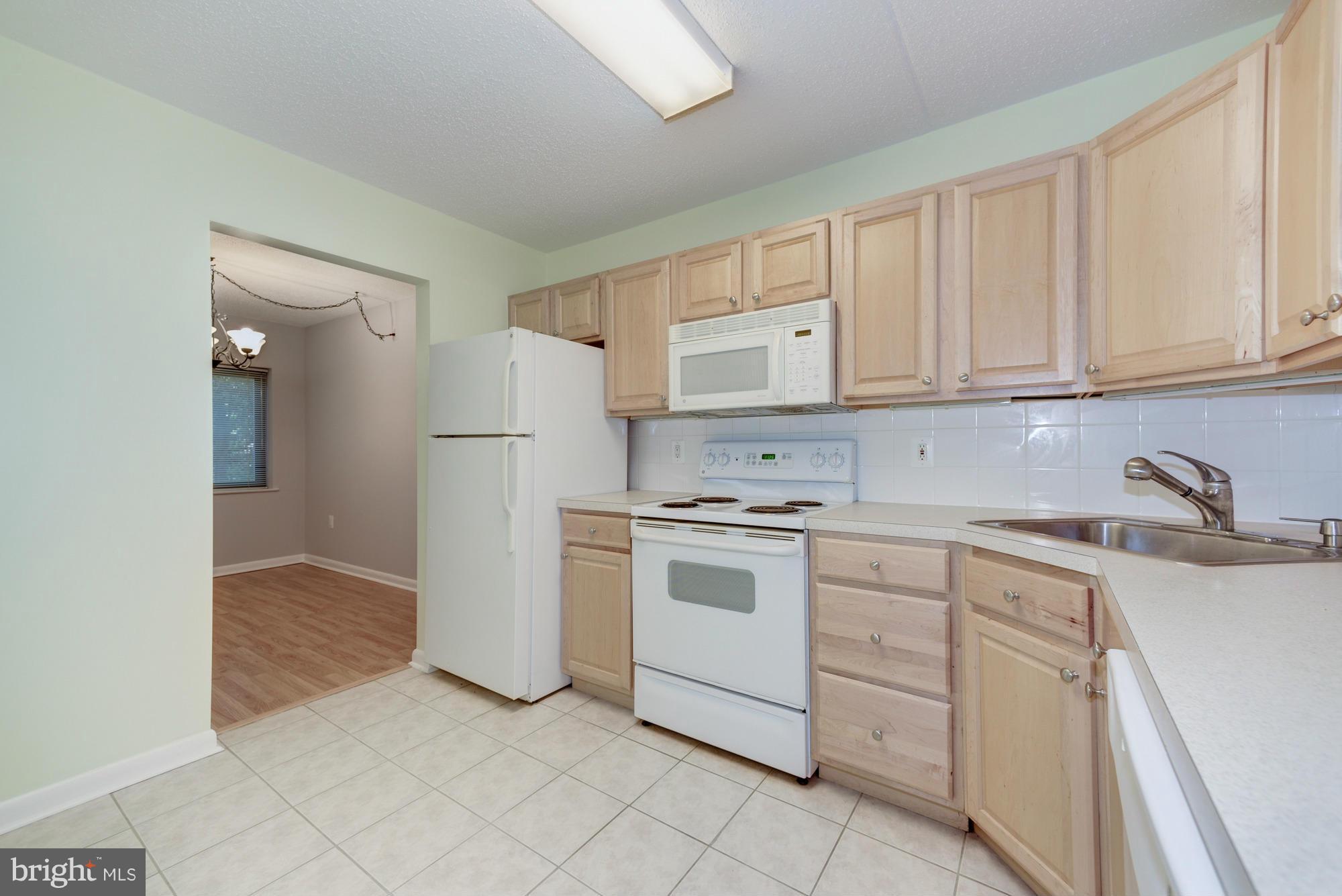 11727 Ledura Court, Unit T2 Reston, VA 20191 - Photo 9 of 18 a kitchen with white cabinets and white appliances