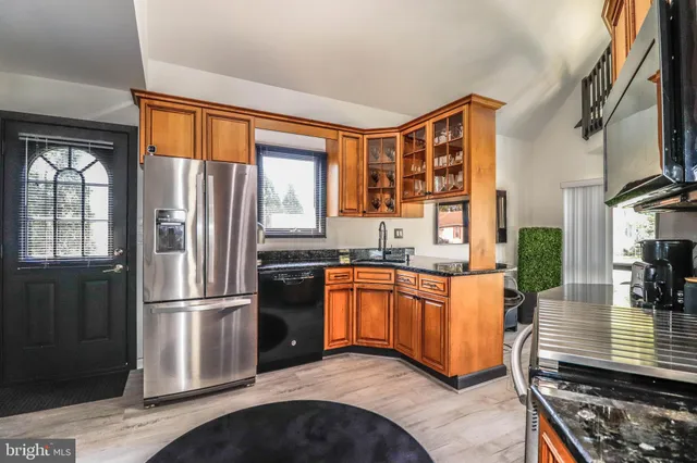 a kitchen with stainless steel appliances granite countertop a refrigerator a stove a sink and a microwave