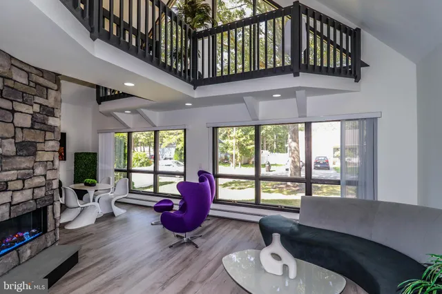 a living room with furniture fireplace and a large window