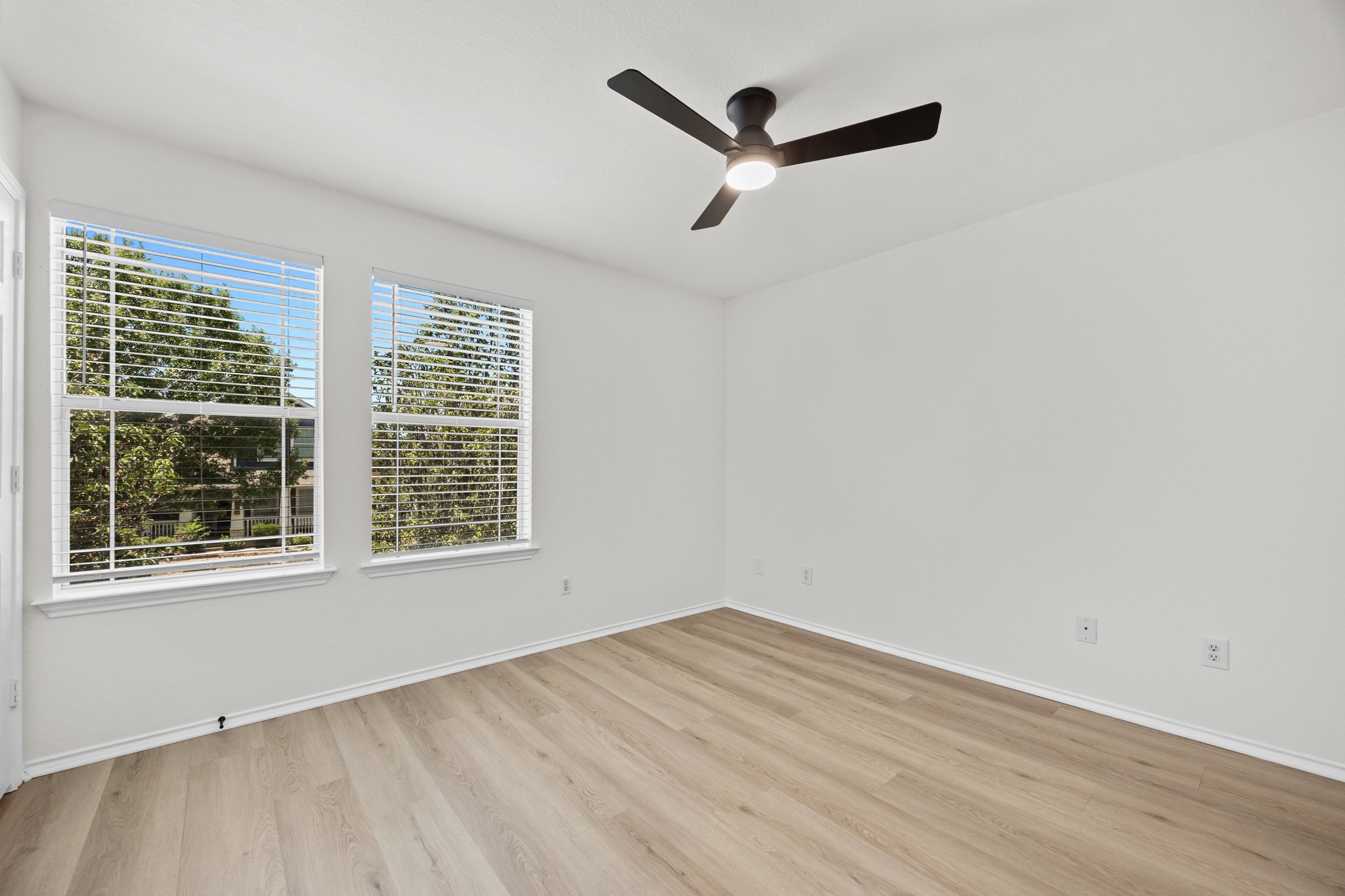 1818 Lost Maples Loop Cedar Park, TX 78613 - Photo 21 of 38 A quiet bedroom featuring light wood flooring and dual windows offering leafy exterior views.