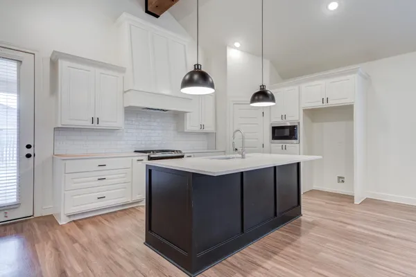 a kitchen with a sink a stove and cabinets
