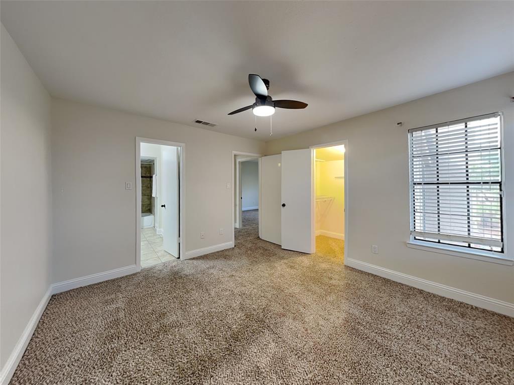 4220 Madera Road Irving, TX 75038 - Photo 18 of 22 Unfurnished bedroom with a spacious closet, visible vents, light carpet, baseboards, and ceiling fan