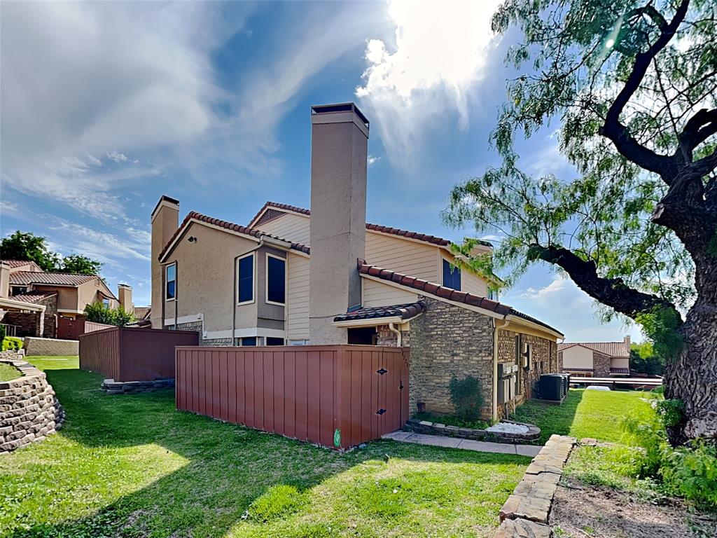 4220 Madera Road Irving, TX 75038 - Photo 21 of 22 Back of property with a tiled roof, central air condition unit, a chimney, fence, and a yard