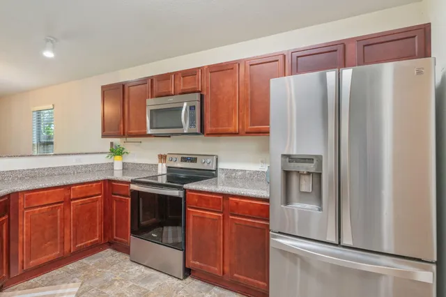 a kitchen with stainless steel appliances granite countertop a refrigerator and a sink