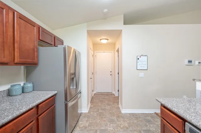 a kitchen with stainless steel appliances granite countertop a refrigerator and a sink