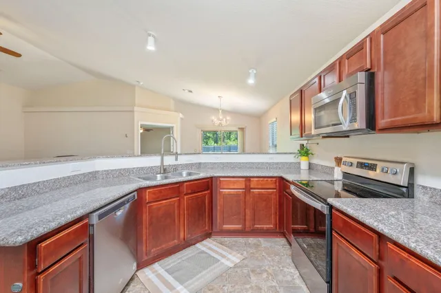 a kitchen with stainless steel appliances granite countertop a sink stove and cabinets