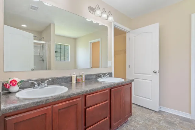 a bathroom with a granite countertop sink and a mirror