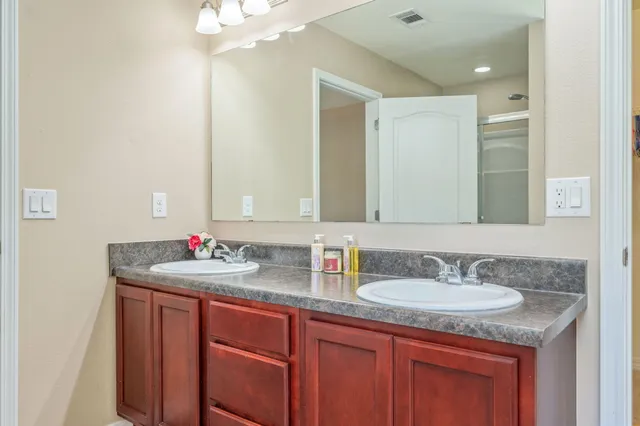 a bathroom with a granite countertop sink and a mirror