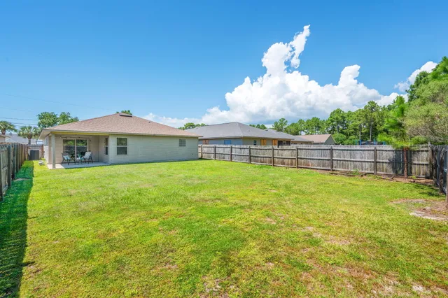 a view of a house with a yard and sitting area