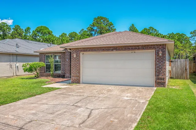 a front view of a house with a yard and potted plants