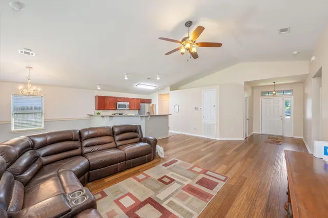a living room with furniture and a wooden floor