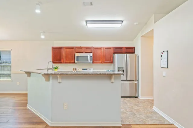 a kitchen with stainless steel appliances a refrigerator and microwave
