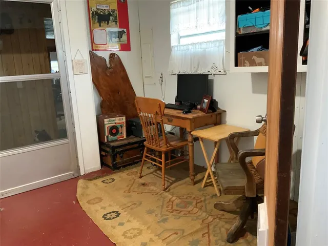 a view of a workspace with furniture and a window