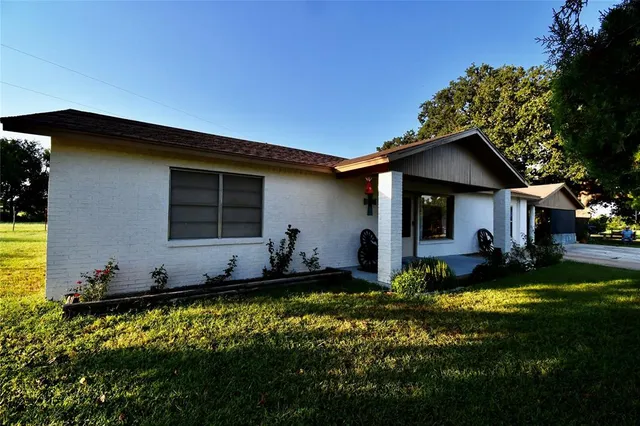a view of house with garden and swimming pool