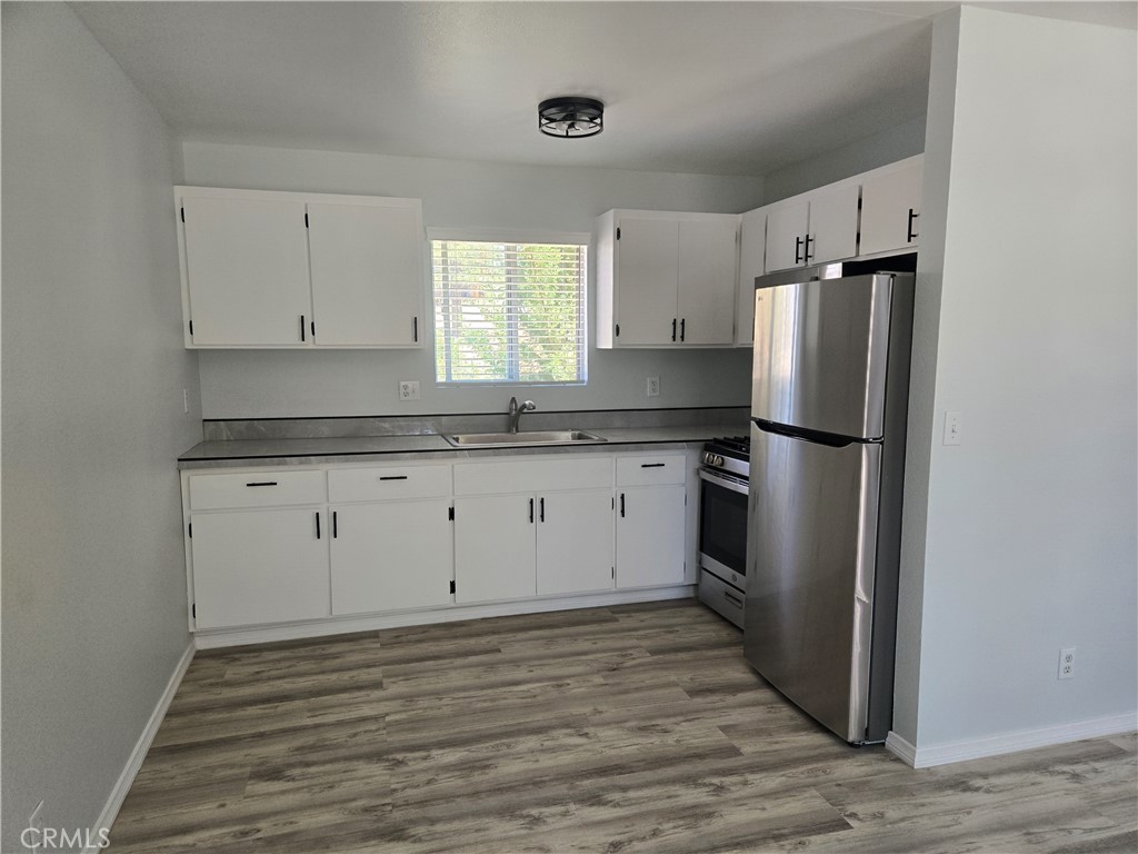 a kitchen with granite countertop white cabinets and stainless steel appliances