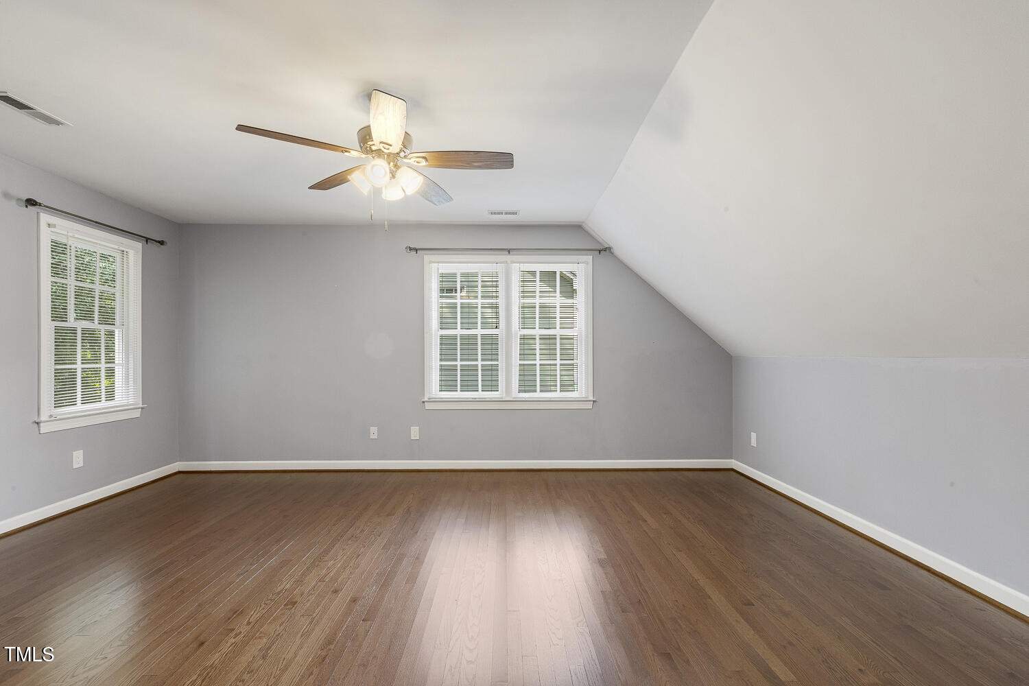 110 Felspar Way Cary, NC 27518 - Photo 40 of 71 an empty room with wooden floor ceiling fan and windows