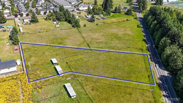 a view of a swimming pool with a bench and trees in the background