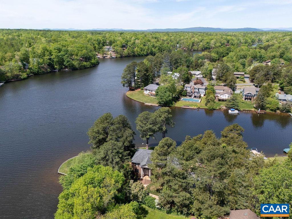 an aerial view of a house with a yard and lake view