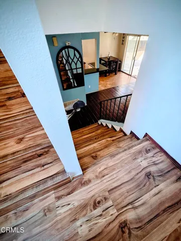 a bed sitting in a bedroom next to a lamp with wooden floor