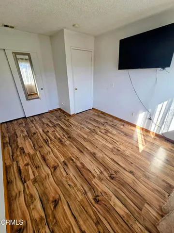a bedroom with a bed and wooden floor