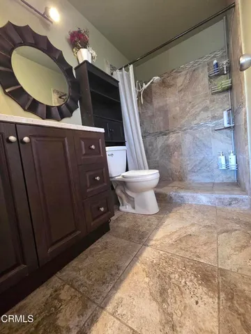 a bathroom with a toilet and a shower