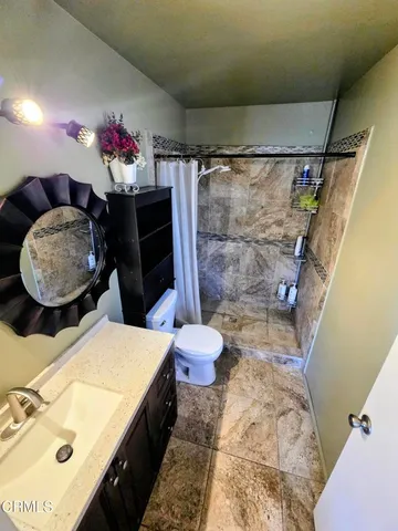 a bathroom with a sink mirror vanity and toilet