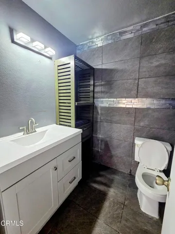 a bathroom with a toilet a sink and mirror