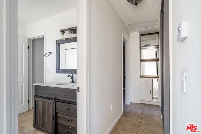 a bathroom with a granite countertop sink two mirror and a vanity