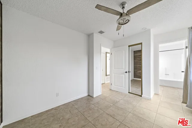 a view of a livingroom with a chandelier fan and windows