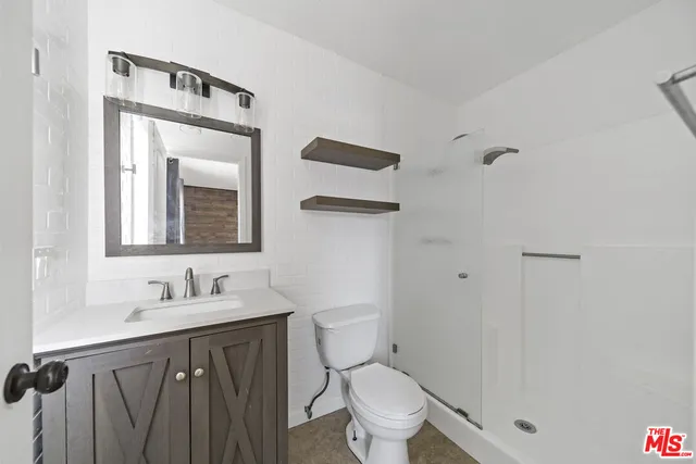 a bathroom with a sink a toilet and a mirror