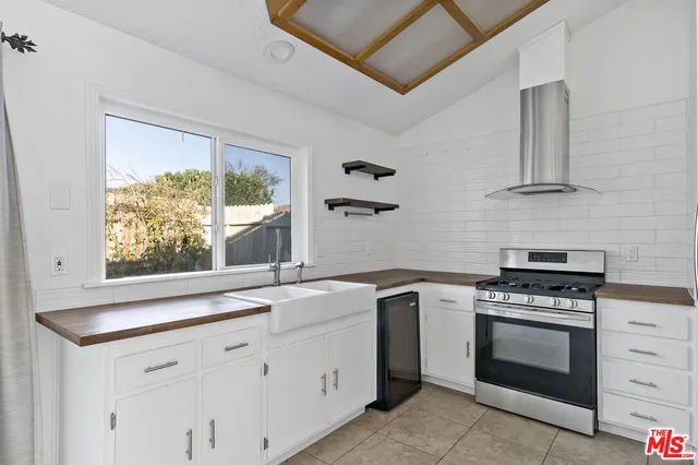 a kitchen with white cabinets and appliances