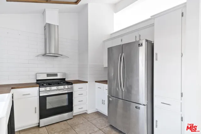a kitchen with stainless steel appliances white cabinets and a refrigerator
