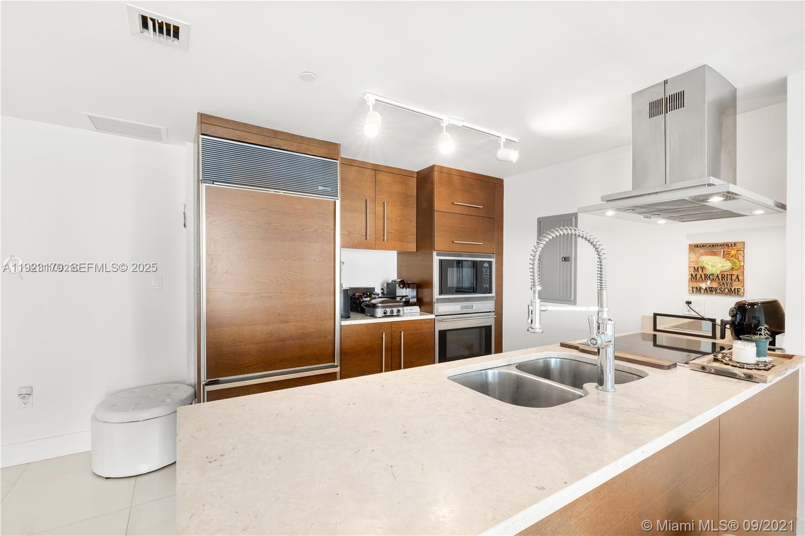495 Brickell Avenue, Unit 1002 Miami, FL 33131 - Photo 2 of 8 a kitchen with stainless steel appliances kitchen island granite countertop a sink and a refrigerator