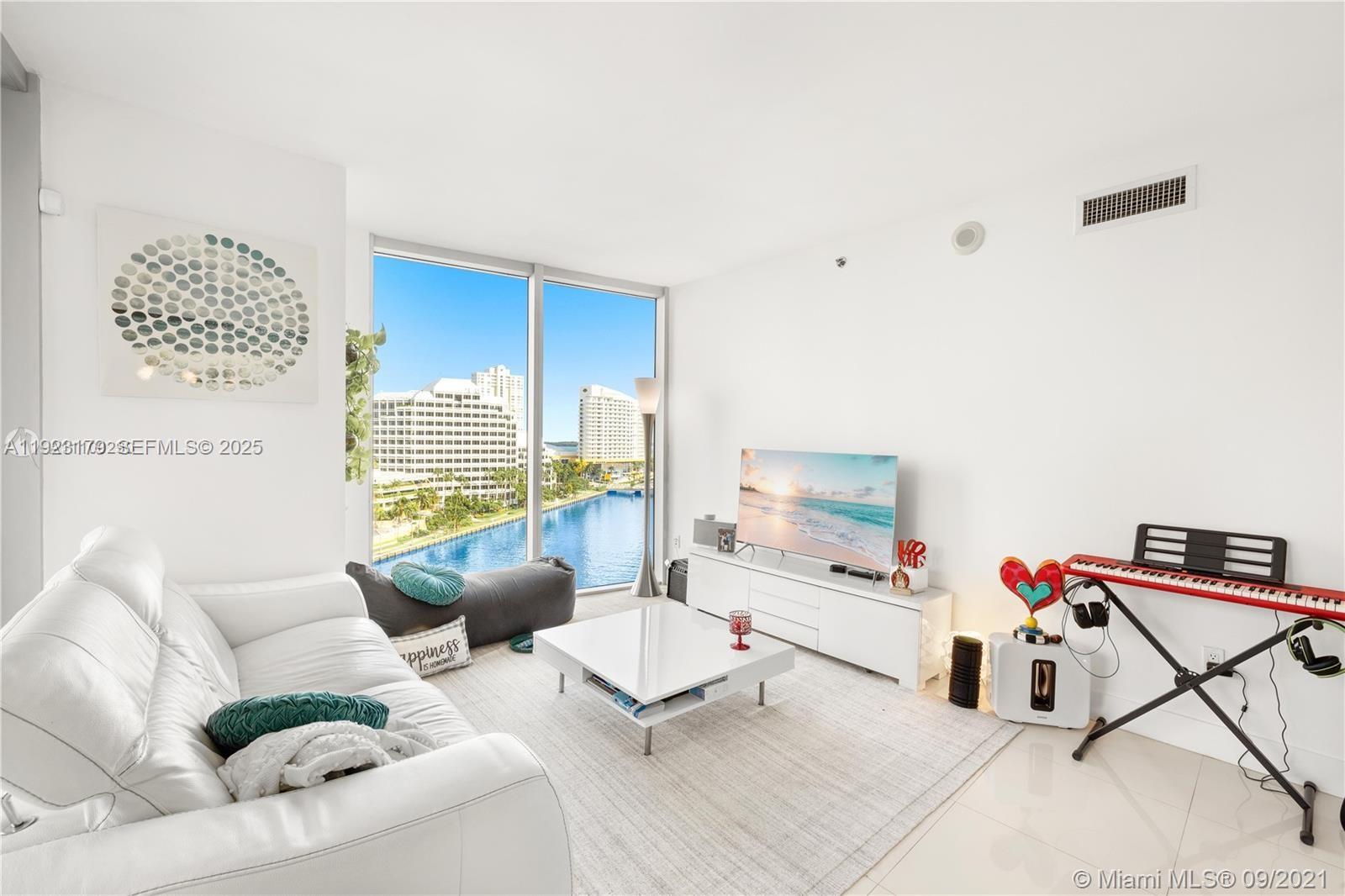 495 Brickell Avenue, Unit 1002 Miami, FL 33131 - Photo 7 of 8 a living room with furniture and a flat screen tv