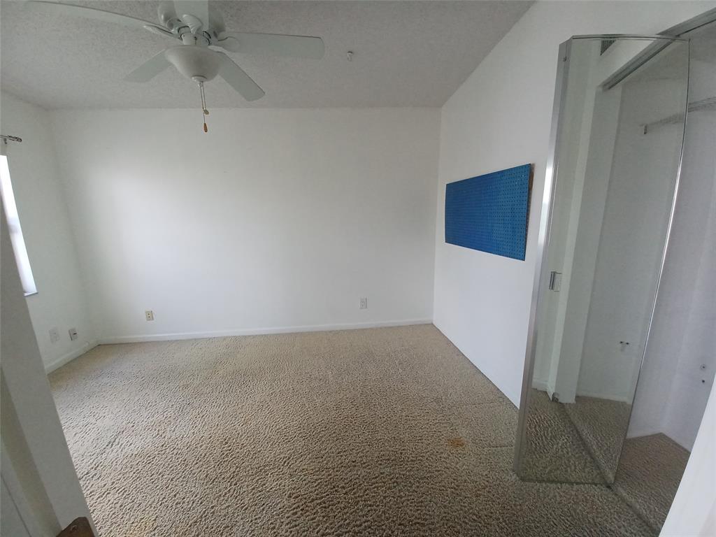 301 North Pine Island Road, Unit 216 Plantation, FL 33324 - Photo 11 of 14 an empty room with a hallway and a chandelier fan