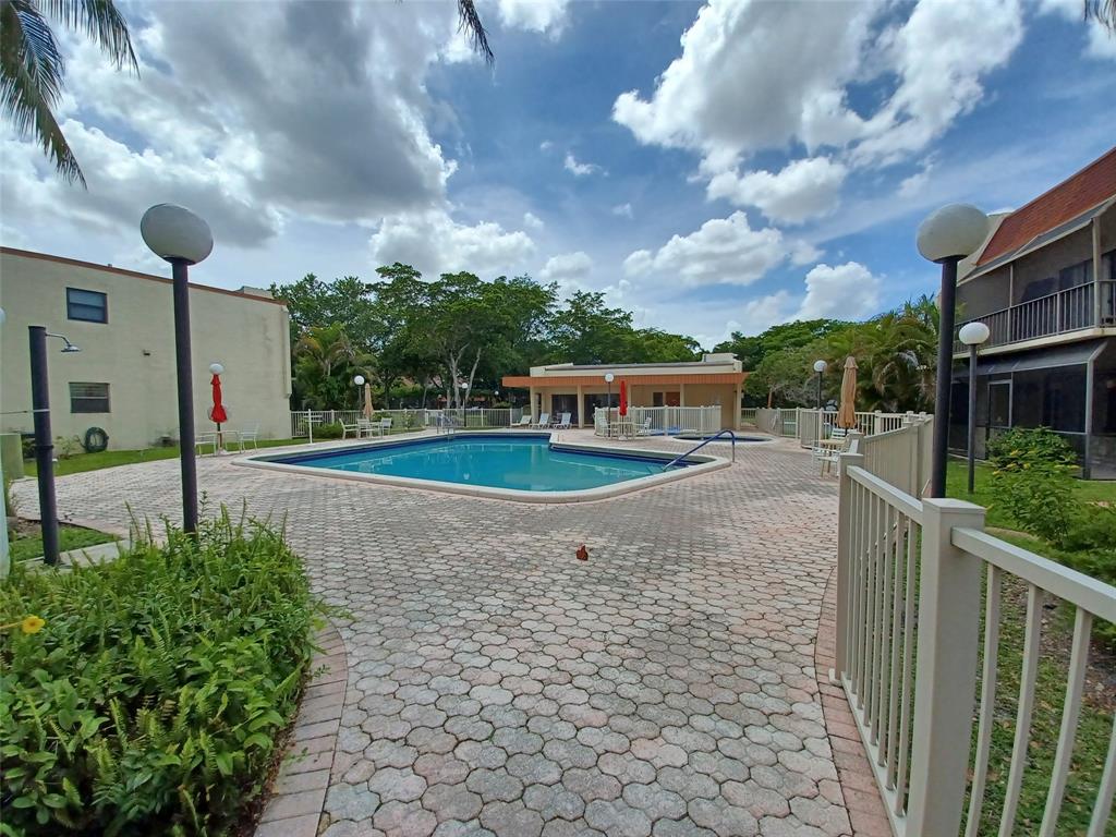 301 North Pine Island Road, Unit 216 Plantation, FL 33324 - Photo 13 of 14 a view of a pathway with a wrought fence
