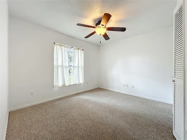 a view of a livingroom with a ceiling fan and window
